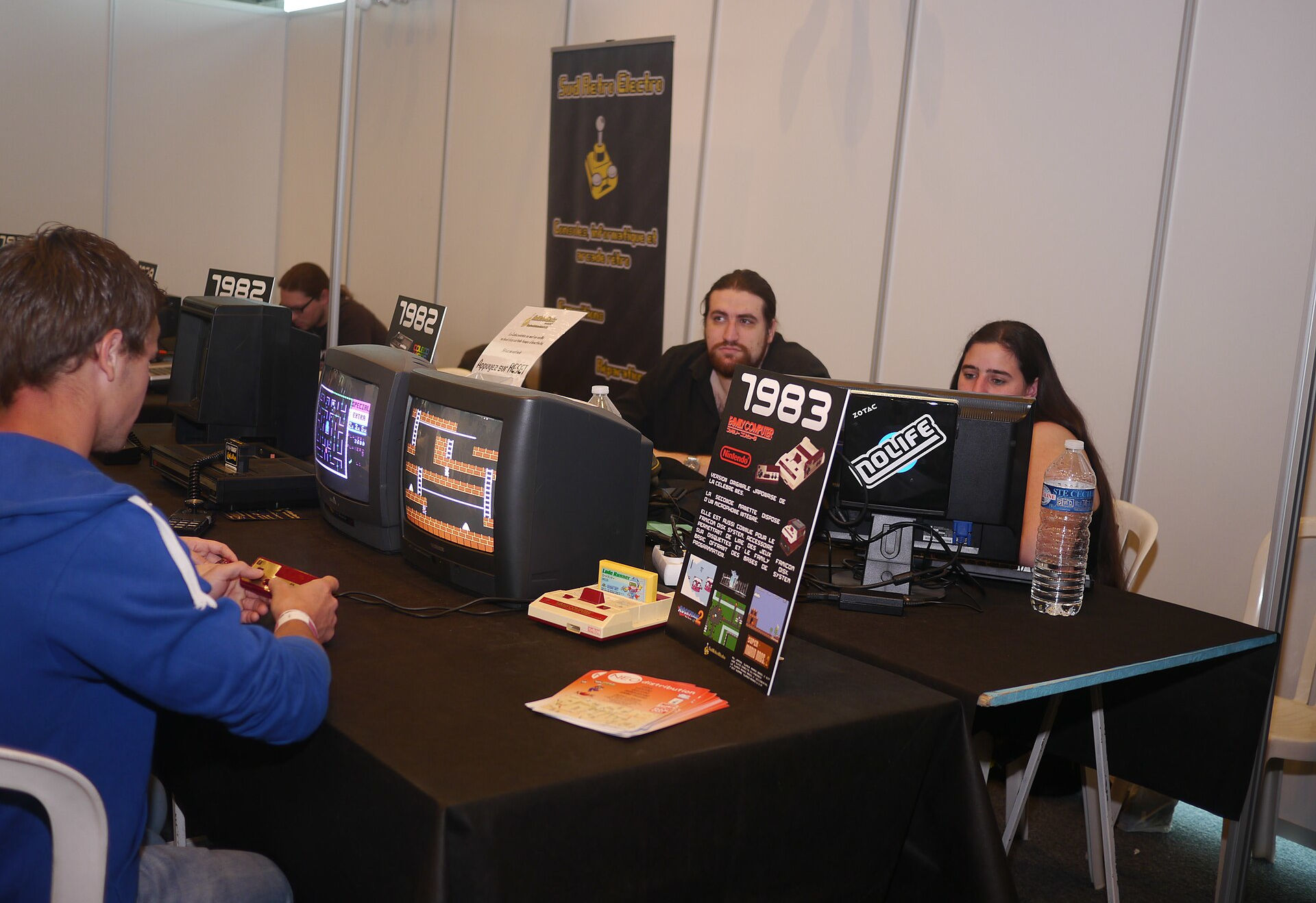 People playing on retro gaming consoles at an event