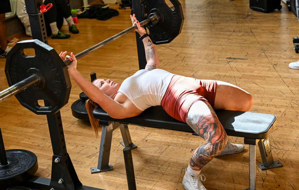 Woman lifting barbell in powerlifting competition